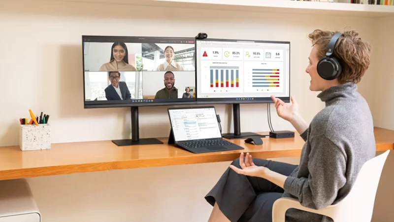 Person im Homeoffice mit zwei Monitoren und Laptop, betrieben von einem Mini PC Windows 11 – maximale Produktivität und effizientes Arbeiten